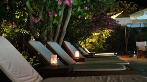 A row of sun loungers with cushions, each with a small table and a candle. - Mr. Dim Exclusive Apart Hotel (Fethiye)