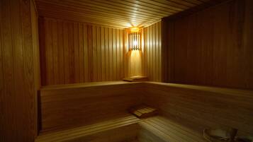 Una sauna de madera con bancos y una lámpara fijada a la pared.