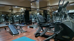 A gym with exercise equipment, a mirror, and a wooden floor. - Mr. Dim Exclusive Apart Hotel (Fethiye)