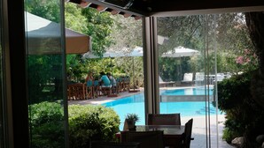 A poolside area with outdoor seating and a glass door leading to a pool. - Mr. Dim Exclusive Apart Hotel (Fethiye)