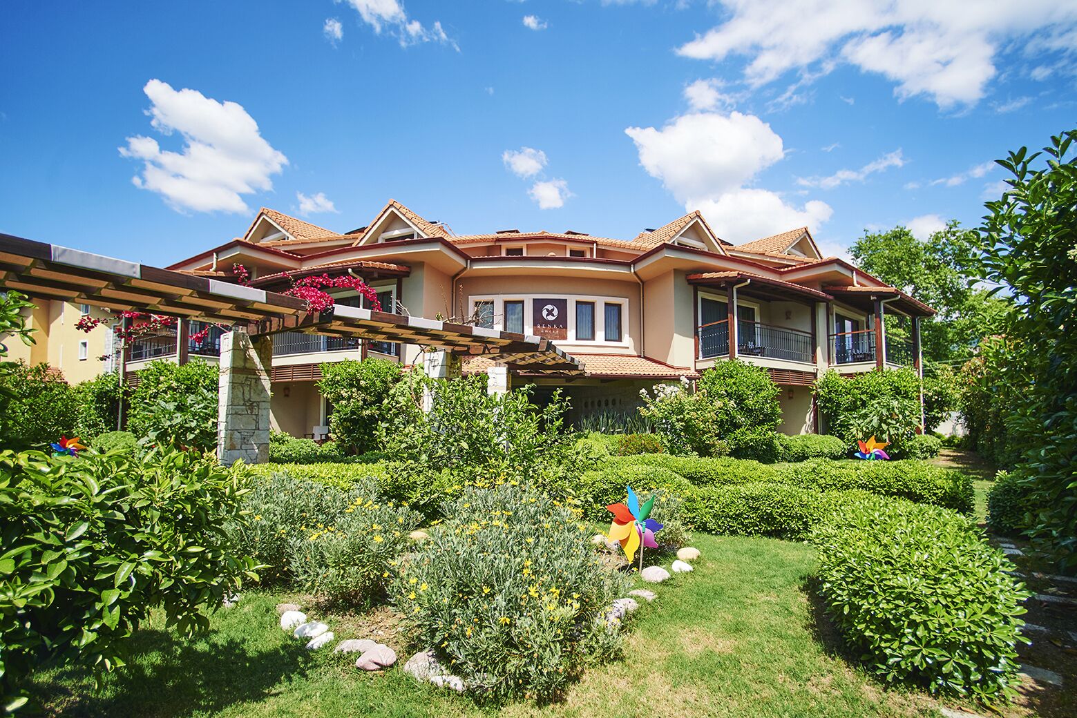 A large, two-story house with a garden in front.