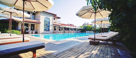 Piscine couverte, piscine extérieure, parasols de plage, chaises longues