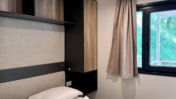 Una camera da letto moderna con un letto, cuscini e asciugamani piegati con cura.