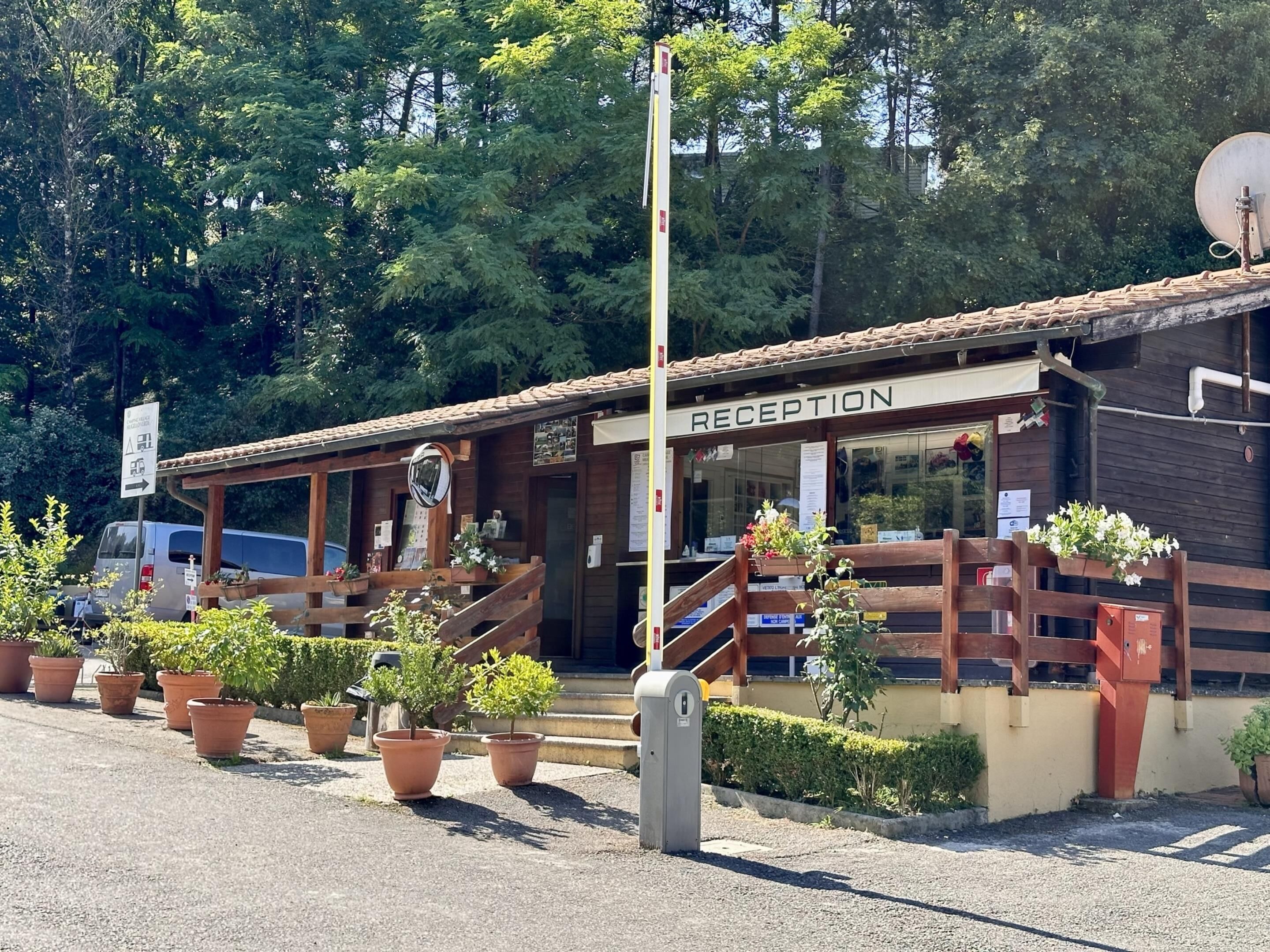 Un área de recepción con fachada de madera, plantas en macetas y una antena parabólica.