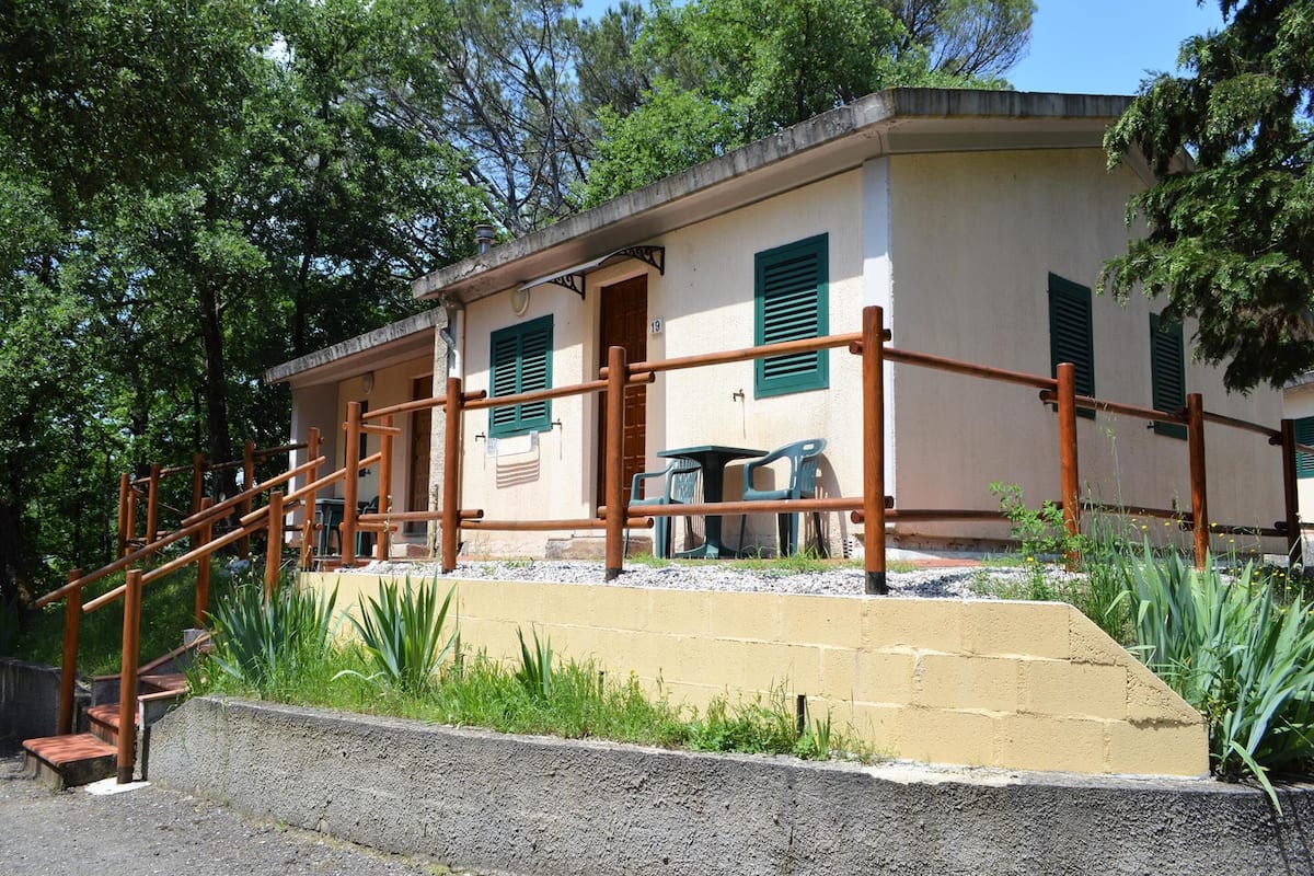 Un edifici amb una escala que mena a una porta, una taula petita a l'exterior i caires.