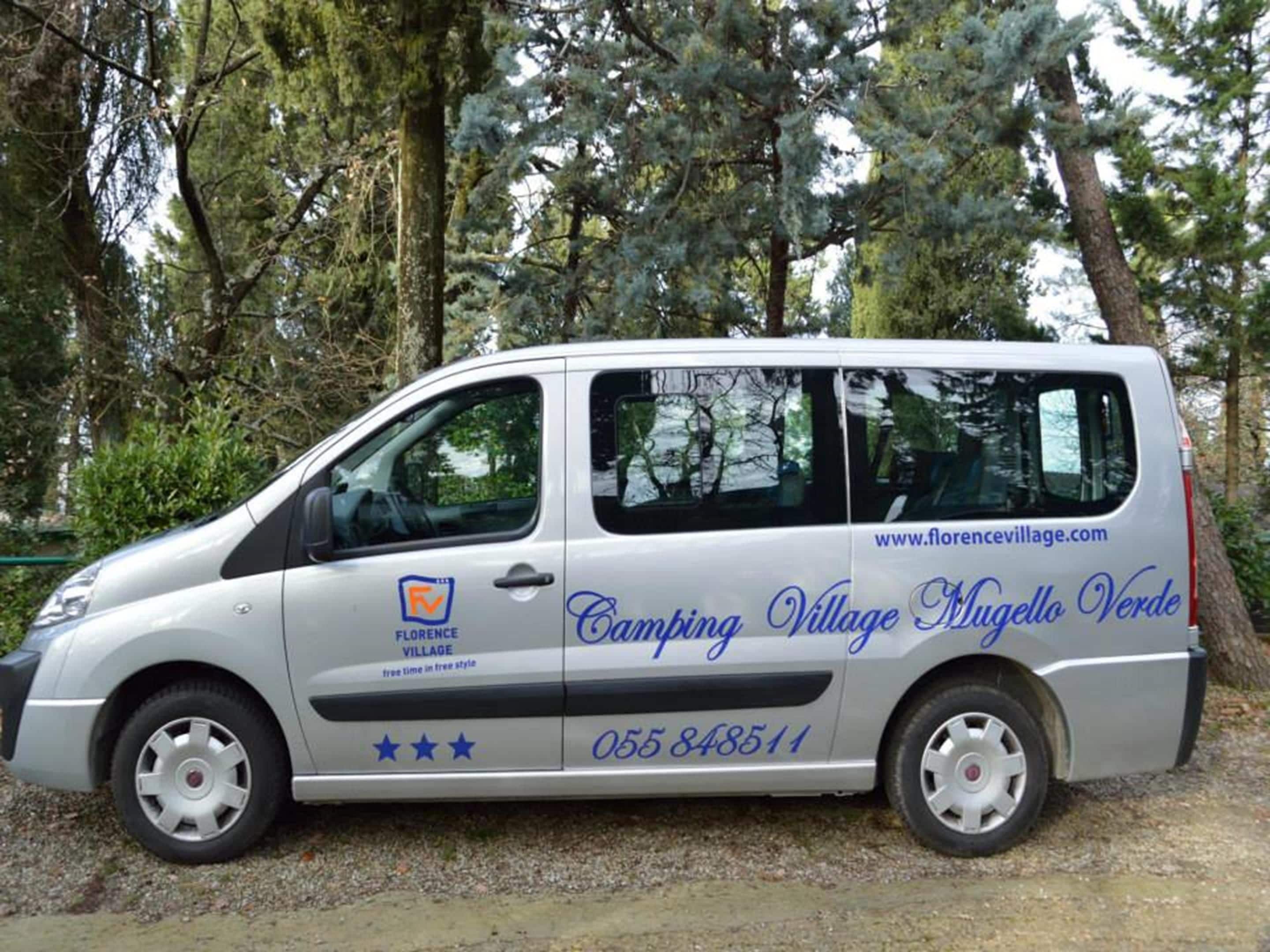 Ein silberfarbener Van mit der Aufschrift "Camping Village Mugello Verde" und einer Telefonnummer.