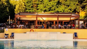 A poolside restaurant with outdoor seating and a lifeguard stand.