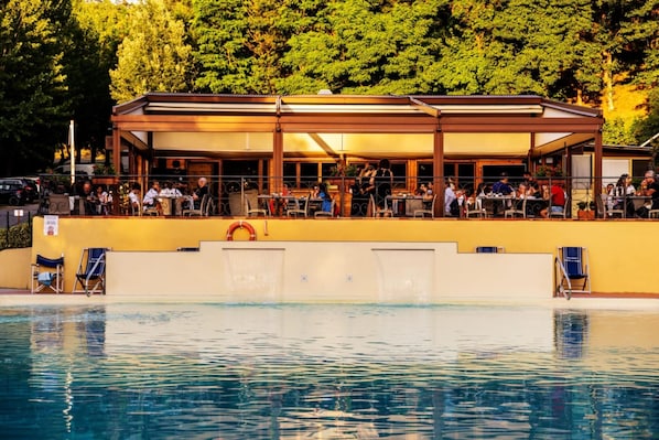 Een seizoensgebonden buitenzwembad, parasols voor strand/zwembad