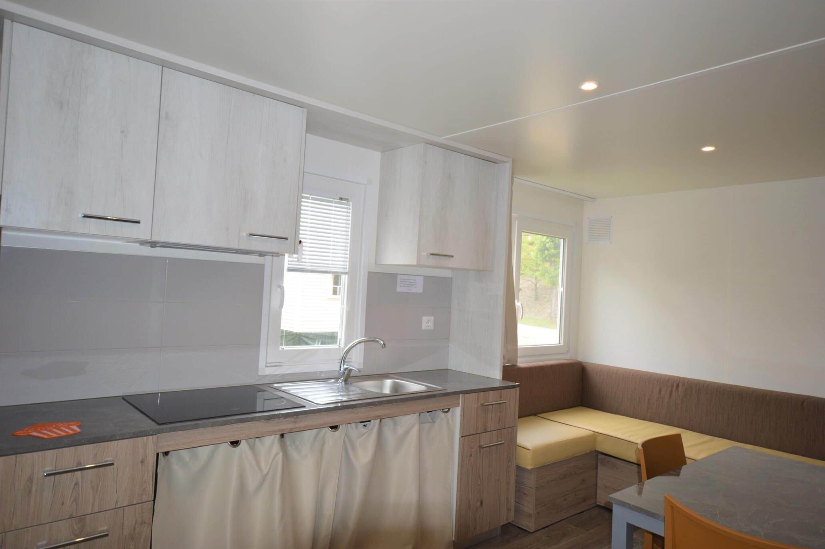 A modern kitchen with white cabinets, a sink, and a window.