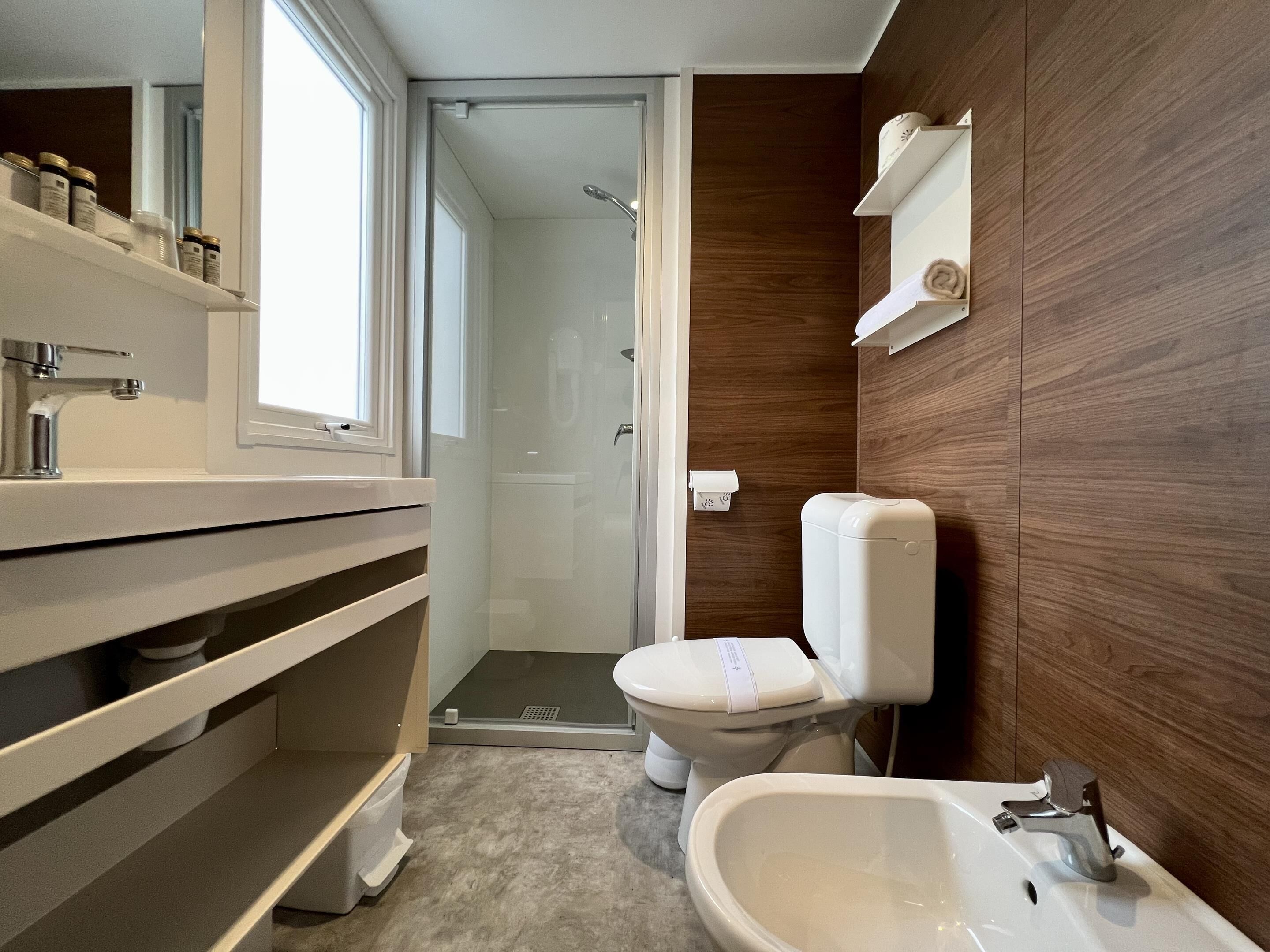 Un baño moderno con ducha, inodoro, bidé y lavabo.