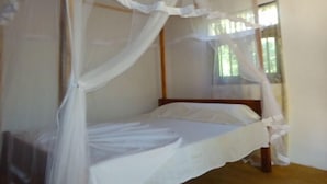 A single bed with a canopy in a room with a window. - Natural Cabanas (Tangalle)