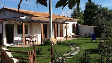 A house with a patio, a lawn, and a stone pathway.
