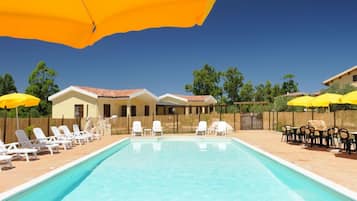 Una piscina al aire libre de temporada, sombrillas, tumbonas
