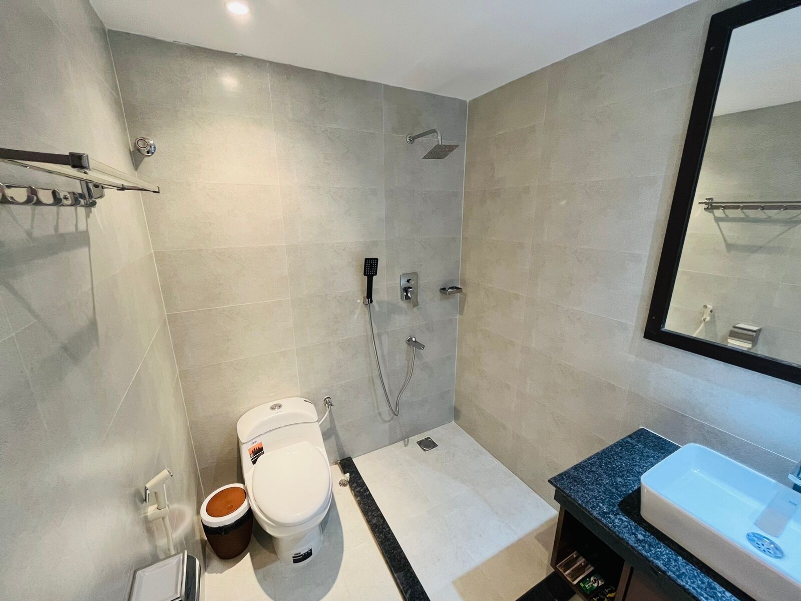 A modern bathroom with a toilet, shower, and sink.