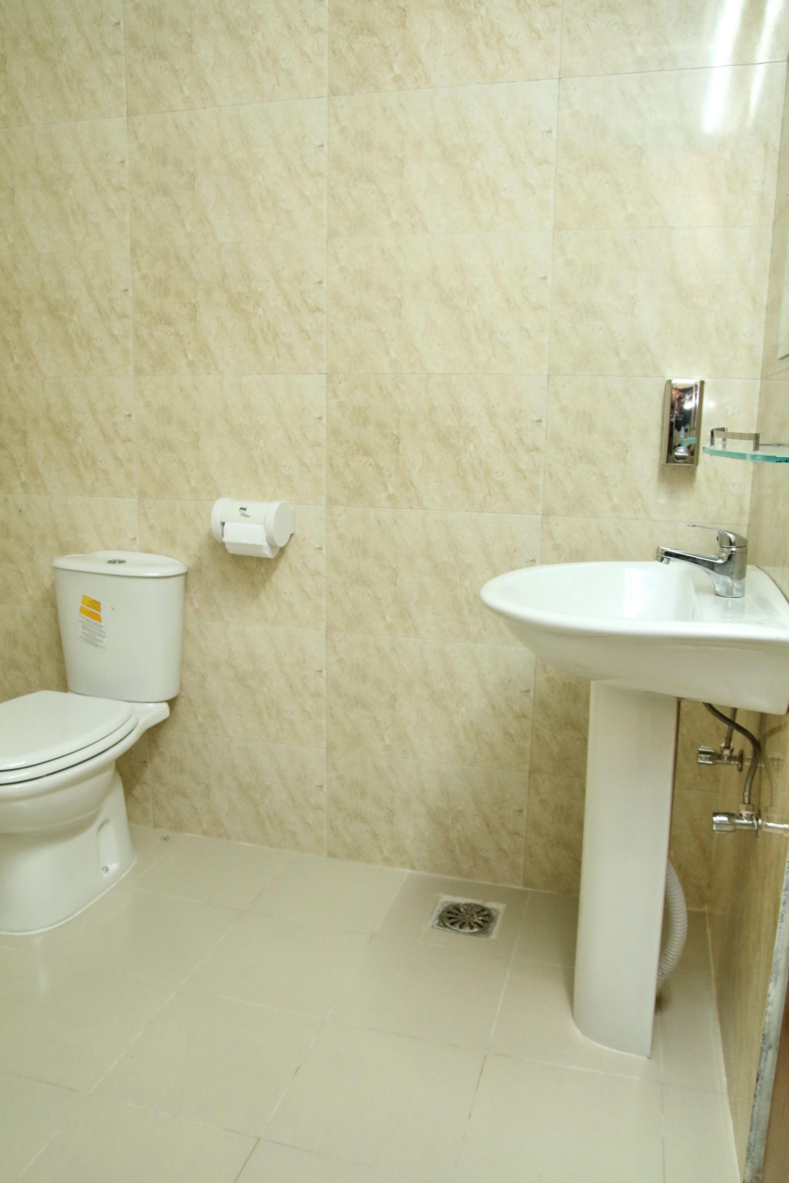 Une salle de bain avec des toilettes, un lavabo et des murs en marbre.