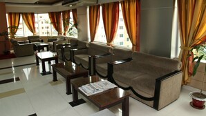 Un hall de hotel con un conjunto de sofás, mesas y plantas en macetas.