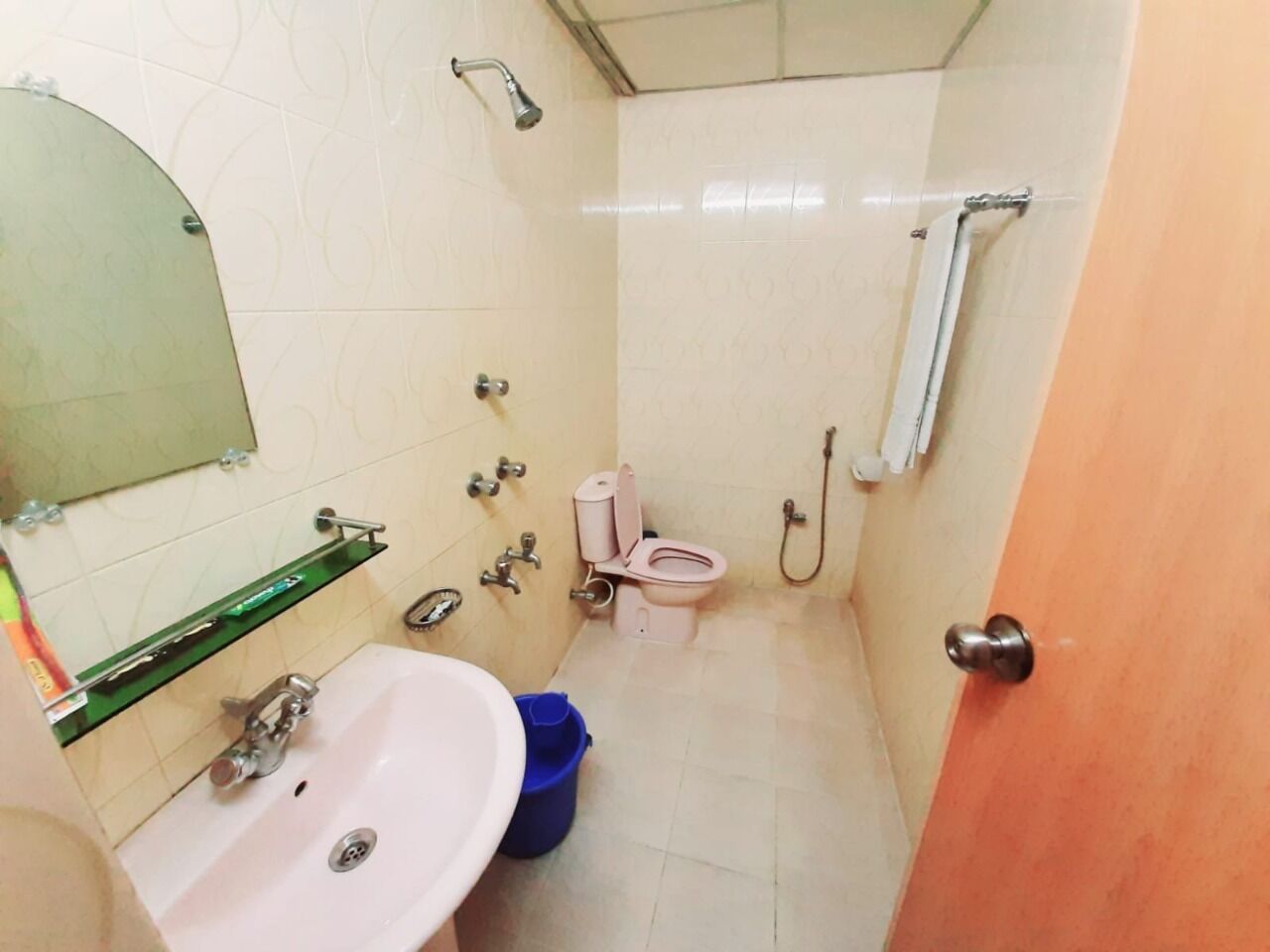 A compact bathroom with a sink, toilet, and shower.