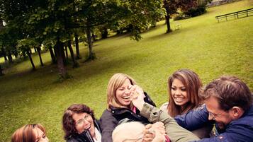 A group of people sitting on grass in a park.