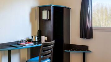 A corner room with a desk, chair, and a cabinet.