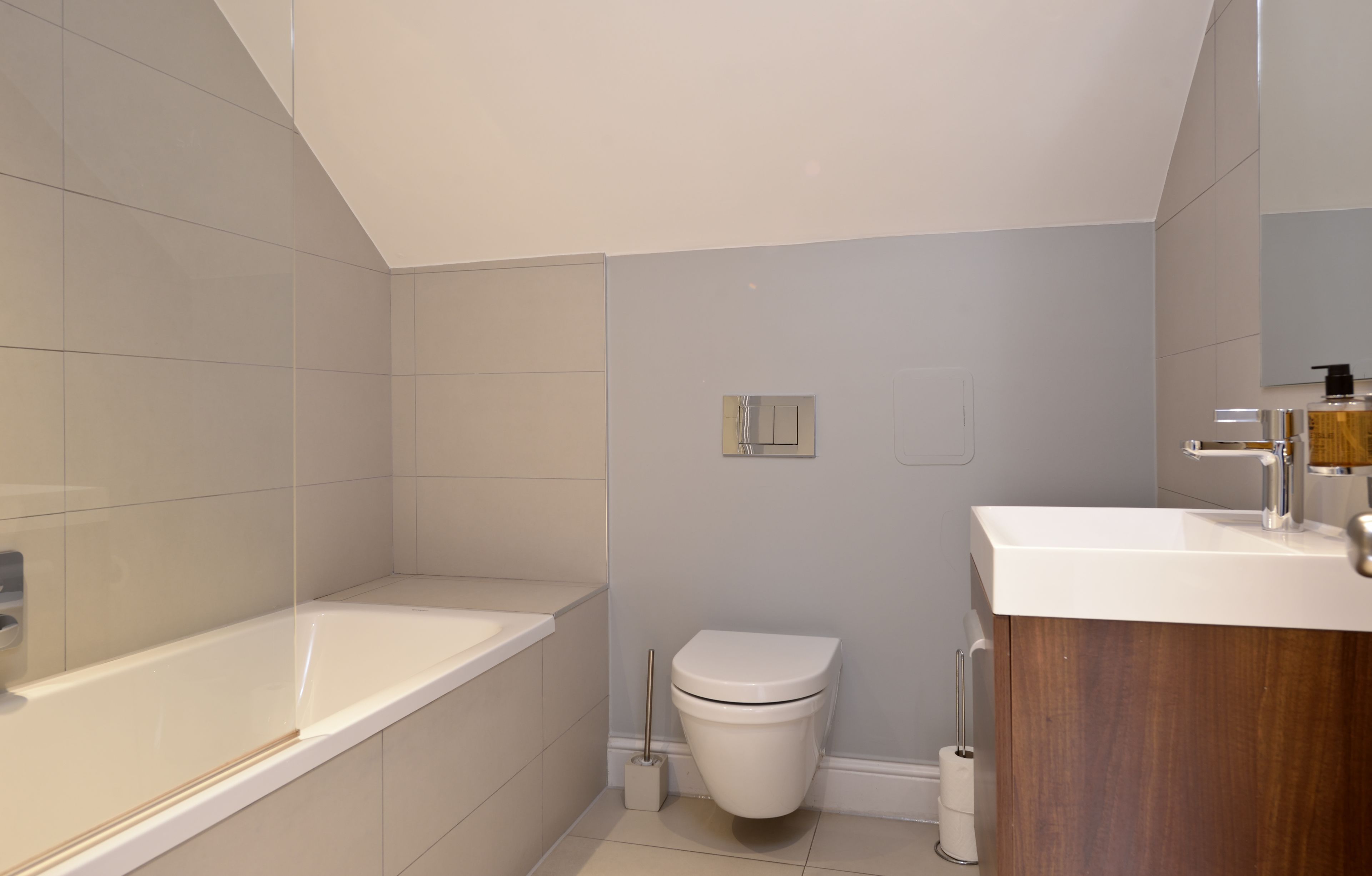 Een moderne badkamer met een bad, toilet en wastafel.