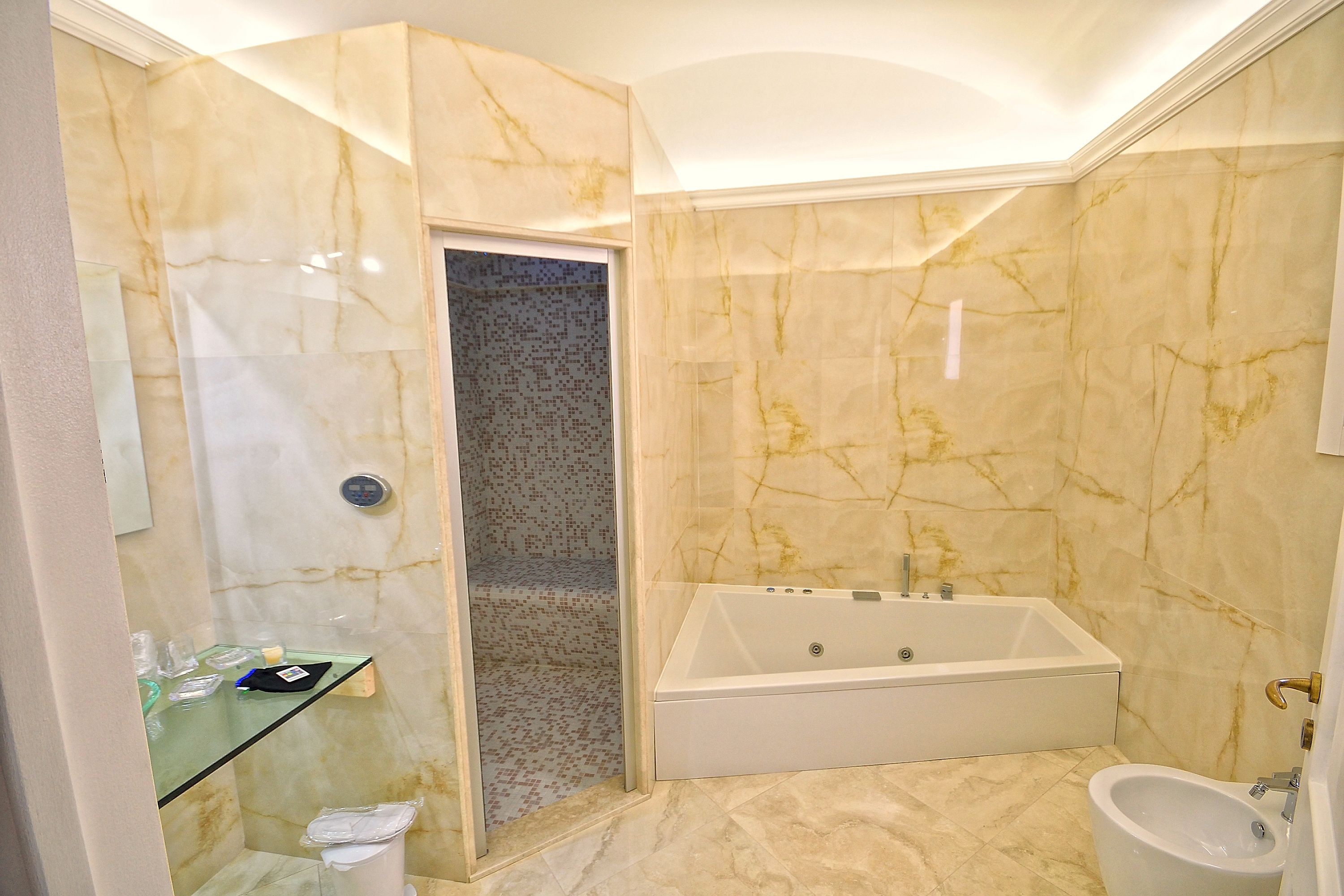 A bathroom with a bathtub, a shower, and a bidet.