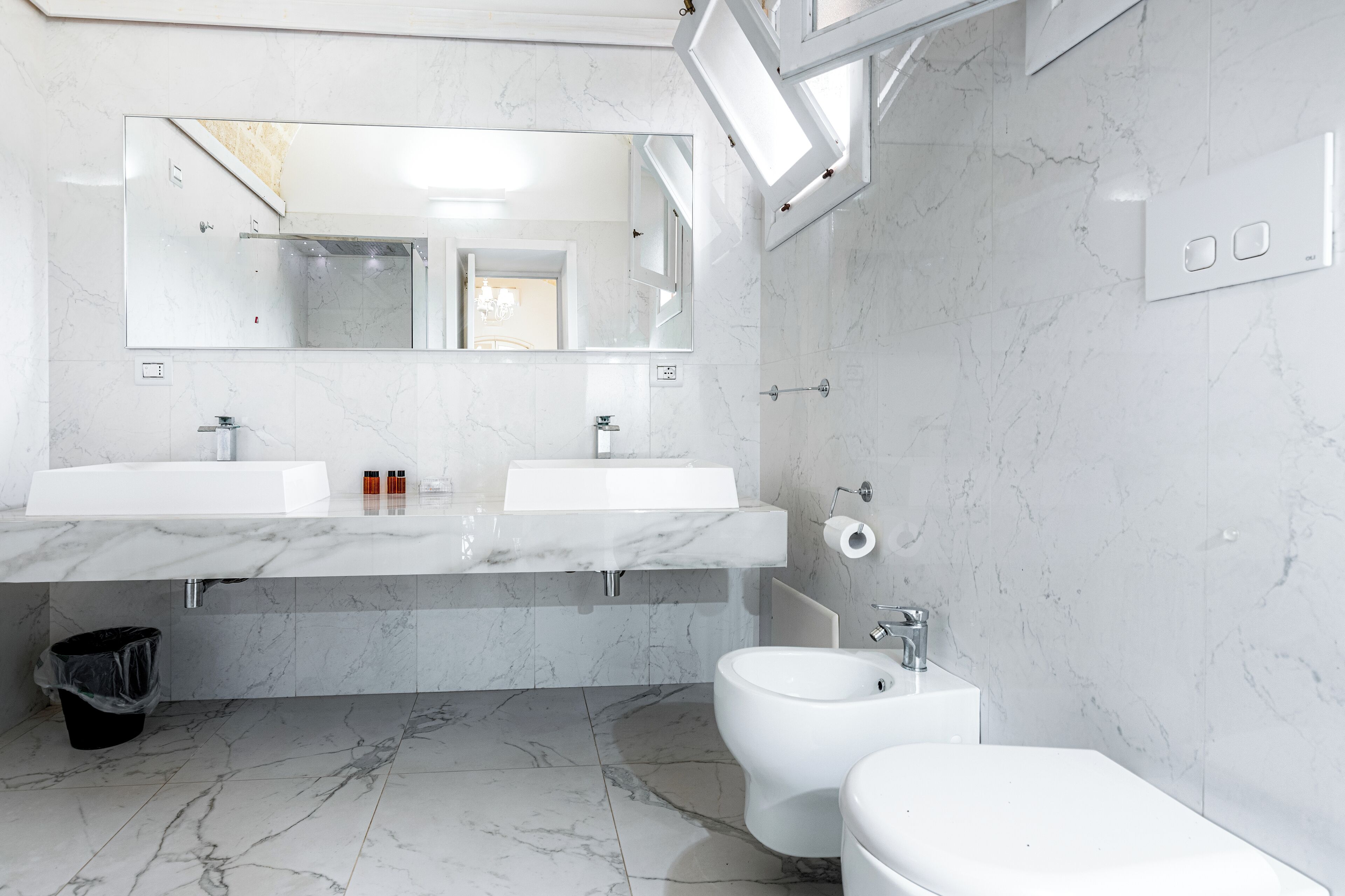 Une salle de bain moderne avec deux lavabos, un bidet et des toilettes.