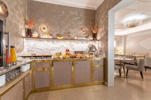 Una cocina moderna con encimeras de mármol, una mesa de buffet y un comedor con mobiliario contemporáneo.