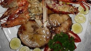 A seafood platter with shrimp, fries, and a steak, garnished with lime and parsley. - Coppenrath (Tangalle)