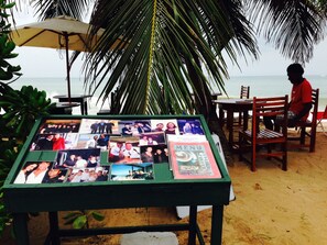 A table with a menu and photos on a beach setting.
