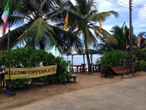 A welcome sign, palm trees, and a beach view.