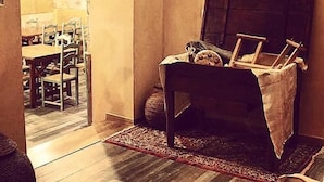 Ein gemütliches Zimmer mit einem Holzkabinett, einem Sessel mit Decke und einem Teppich.