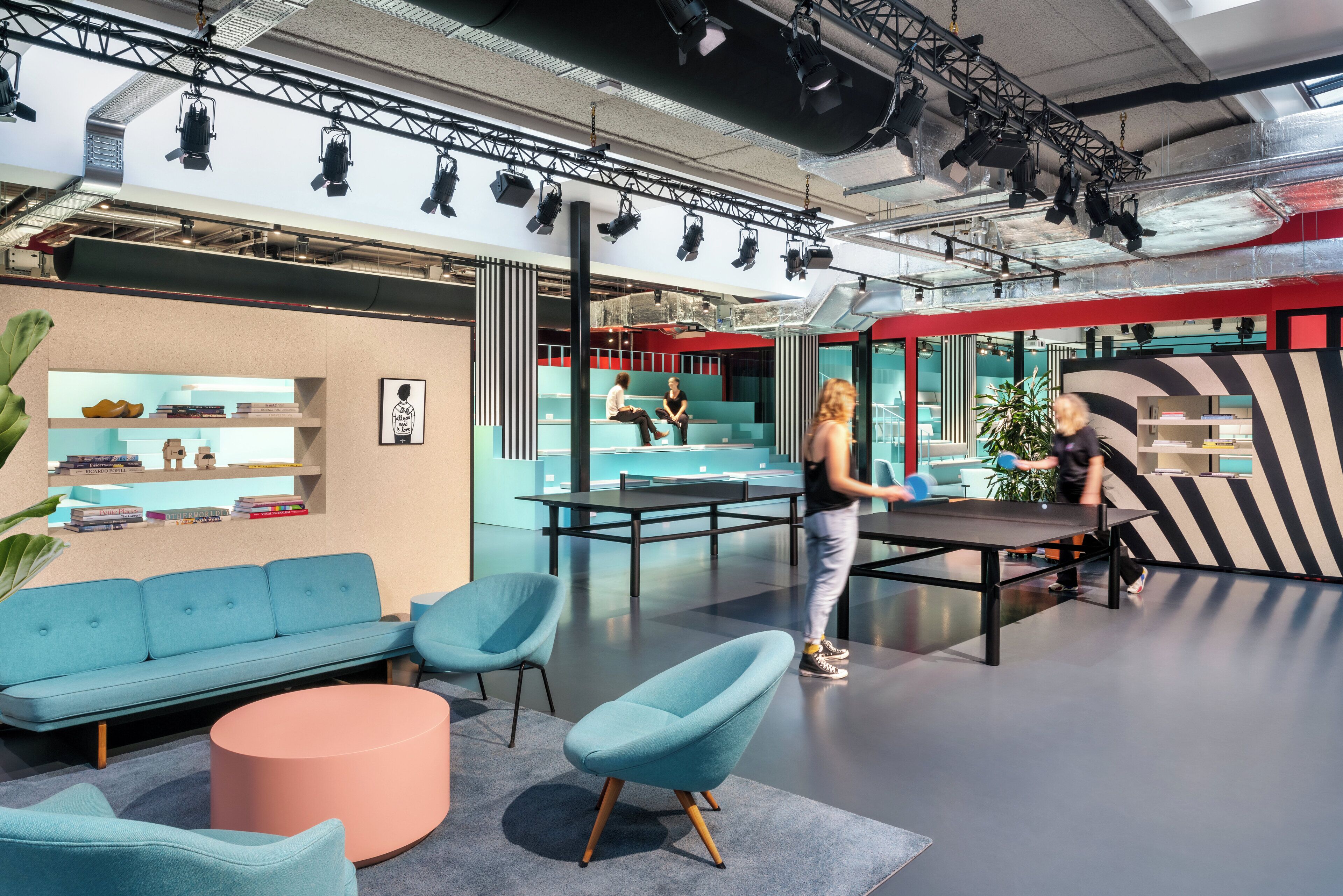 A modern interior with seating, a table, and a stage area.