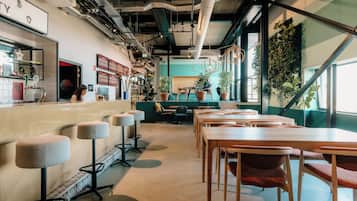 A modern interior with a bar area, seating, and plants.