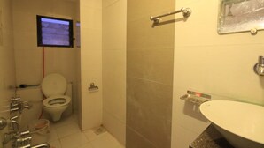 Een badkamer met toilet, douche en wastafel.