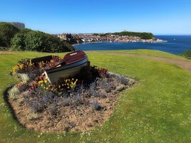 Un bote en un cantero con un paisaje urbano costero al fondo.