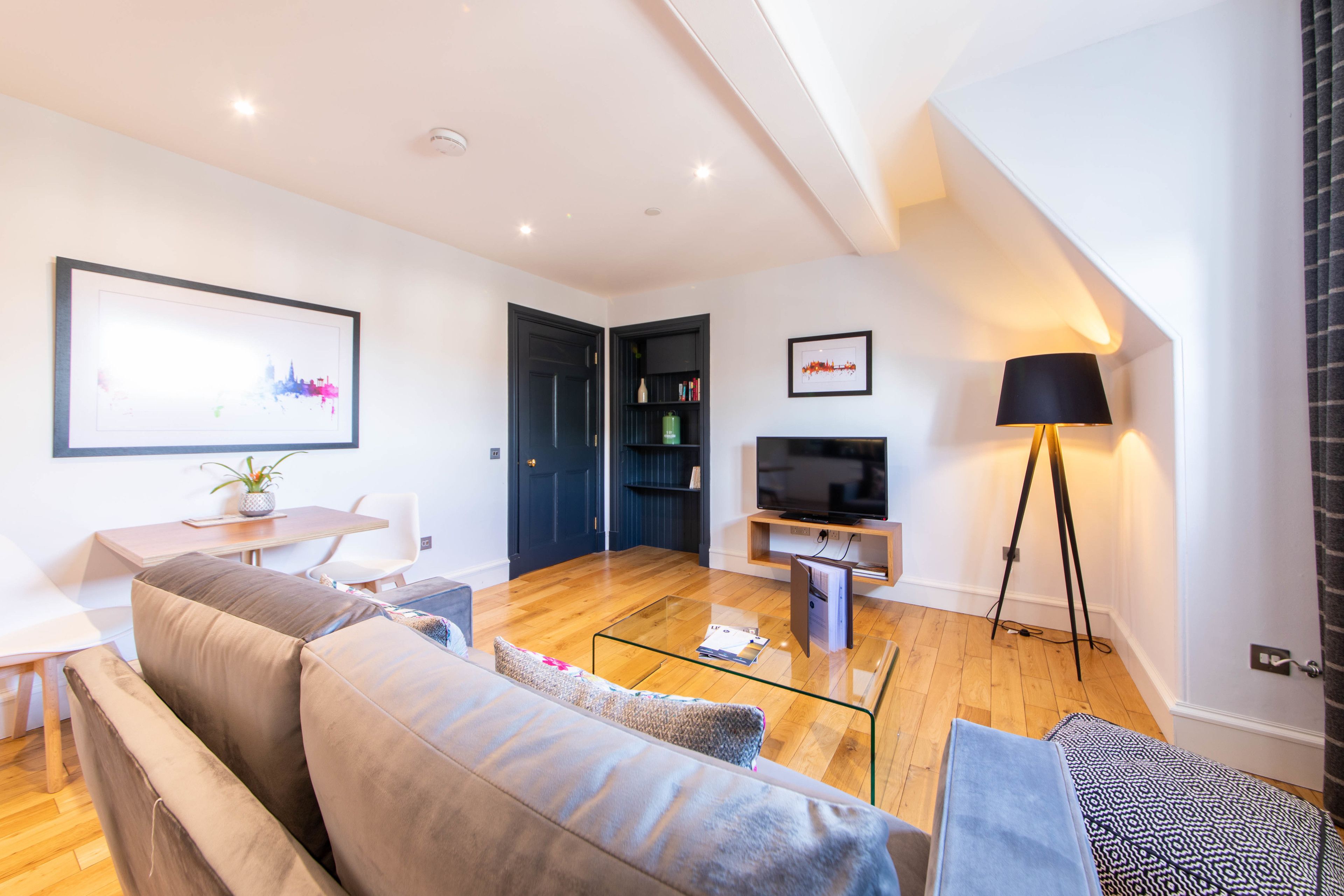 A modern living room with a sofa, coffee table, and a TV stand.