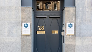 L’entrée d’un immeuble, sur laquelle on peut lire l’inscription : « Collection Linton, numéro 28 ».