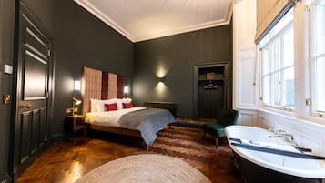 Une chambre dotée d’un grand lit, d’un coin salon et d’une baignoire.