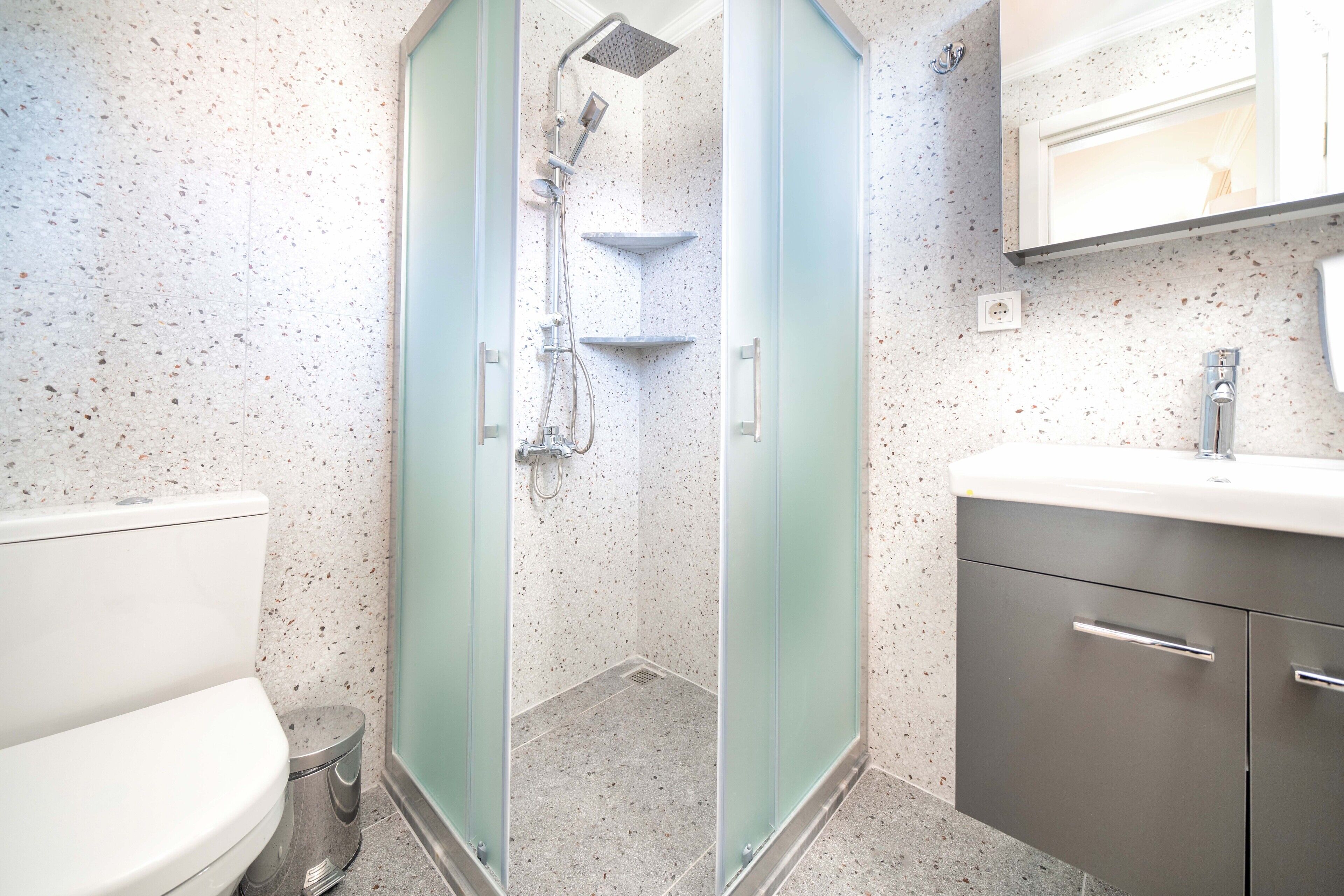 A bathroom with a shower, toilet, and vanity.