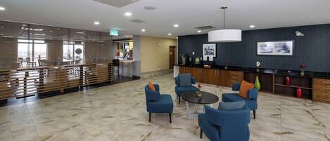 A lobby with seating, a reception desk, and a counter.