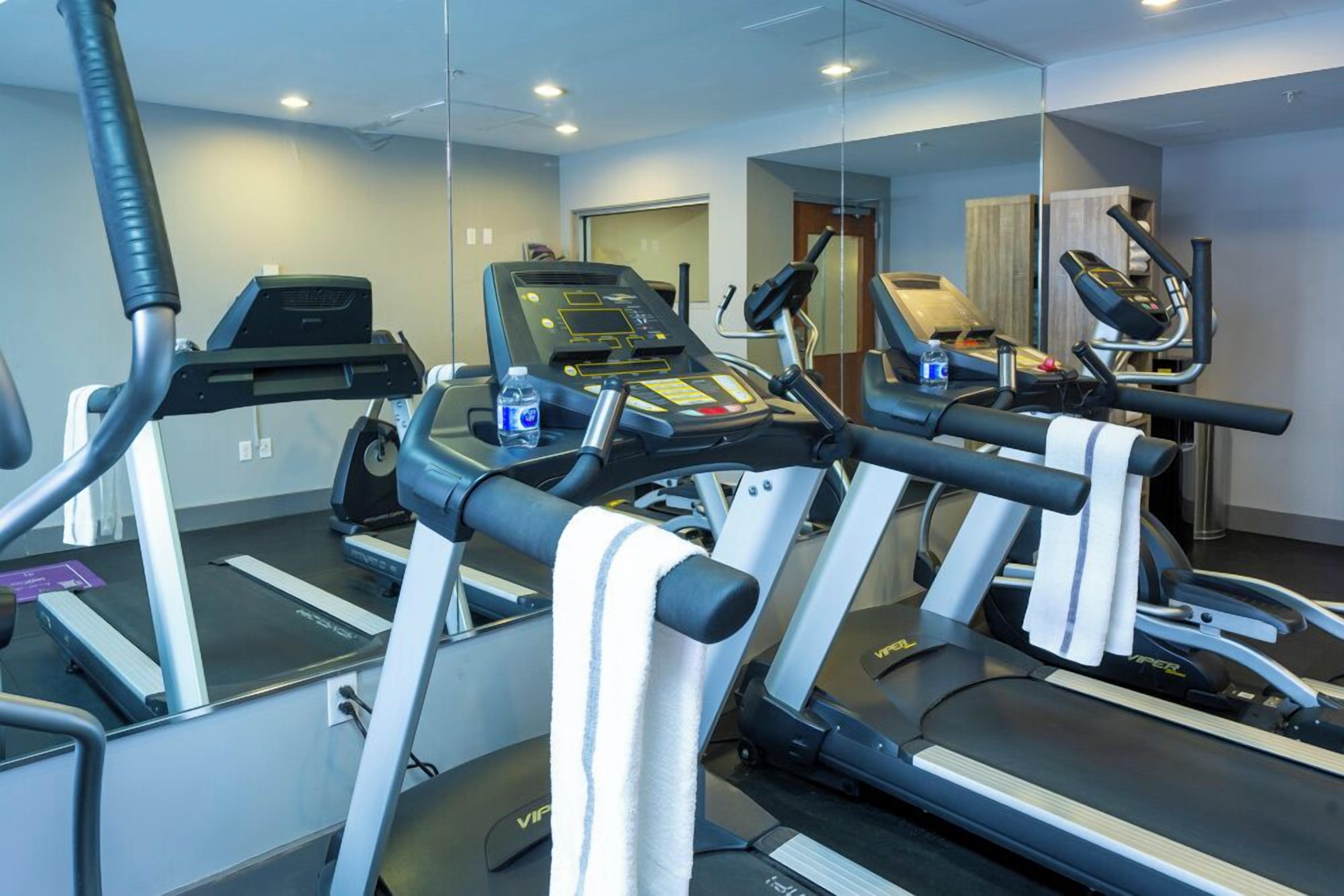 A gym with treadmills, a stationary bike, and a mirrored wall.