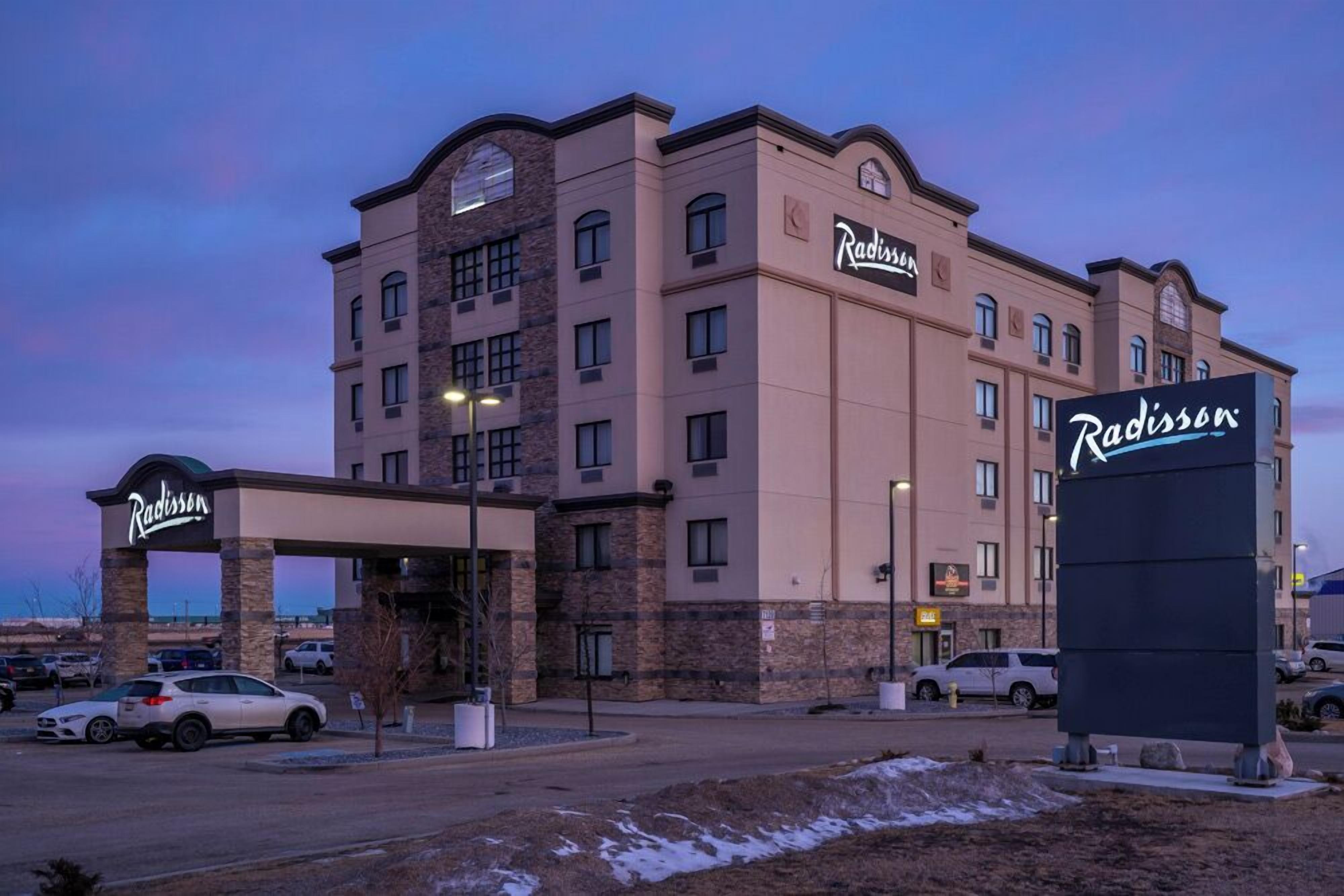A Radisson hotel with a stone facade, multiple floors, and a covered entrance.