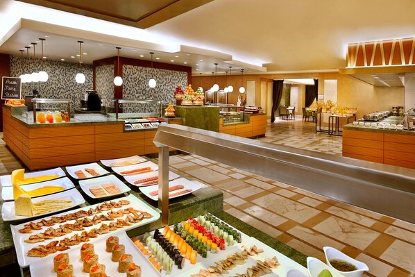 A buffet with various food options, including salads, fruits, and prepared dishes.