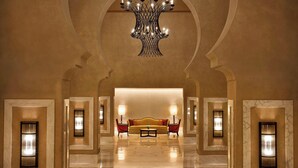 A lobby with a marble floor, a sofa, and wall sconces.