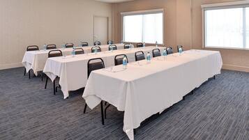 A conference room with multiple tables, each equipped with water bottles and nameplates.