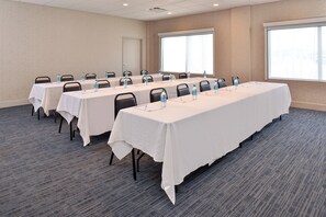 A conference room with multiple tables, each equipped with water bottles and nameplates. - Holiday Inn Express & Suites Farmington Hills - Detroit by IHG (Farmington Hills)
