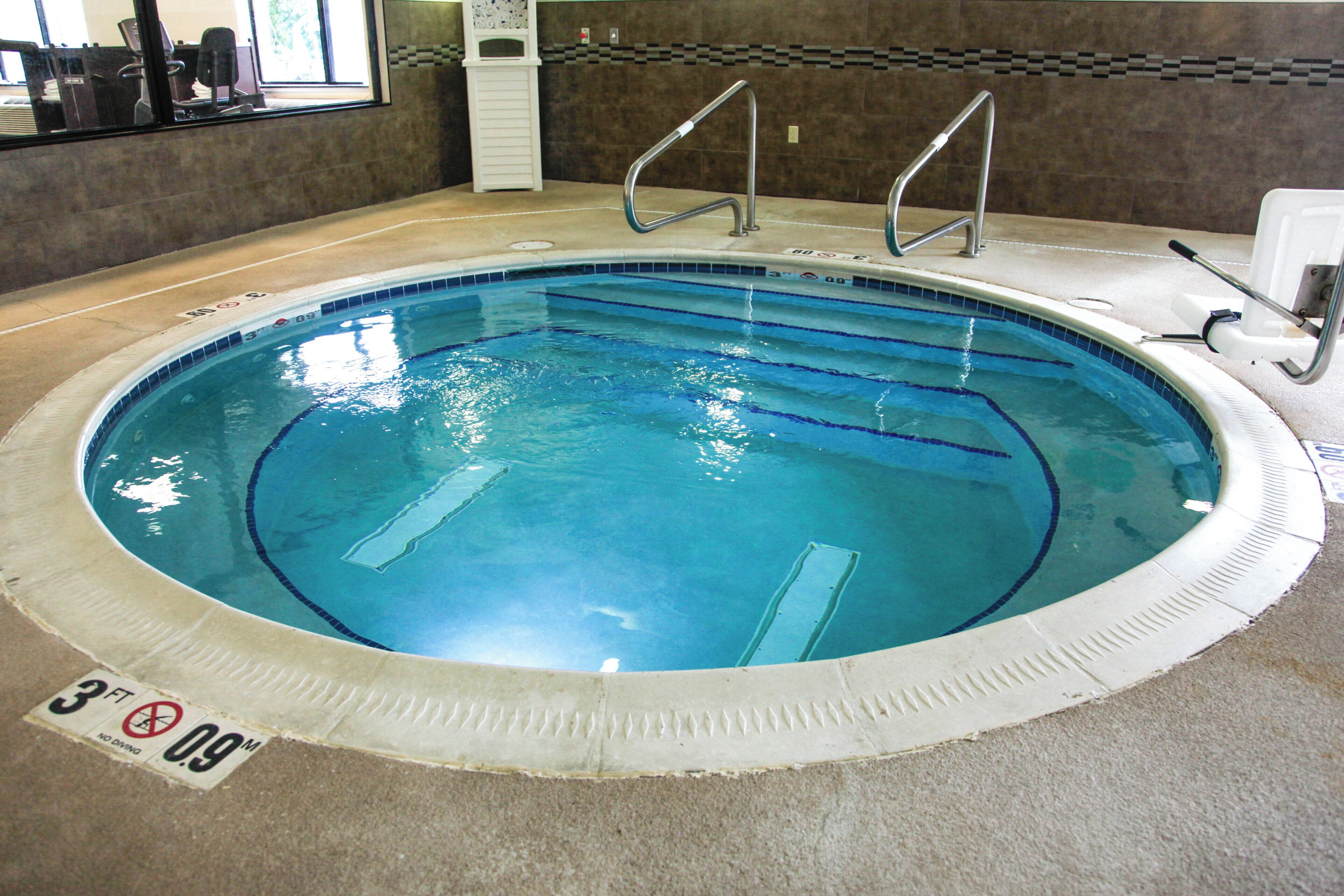 An indoor swimming pool with clear water, marked depth lines, and a no diving sign.