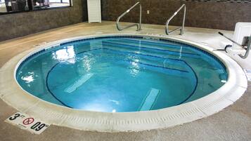 An indoor swimming pool with clear water, marked depth lines, and a no diving sign.