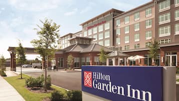 A Hilton Garden Inn hotel with a prominent sign, a parking lot, and a well-maintained lawn.