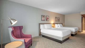 Habitación de hotel con una cama grande, dos mesitas de noche, una silla y un escritorio.